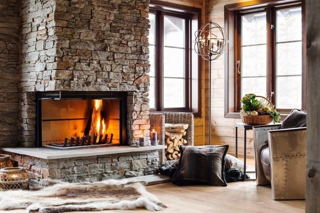 Камин из натурального камня прекрасно смотрится в любом интерьере