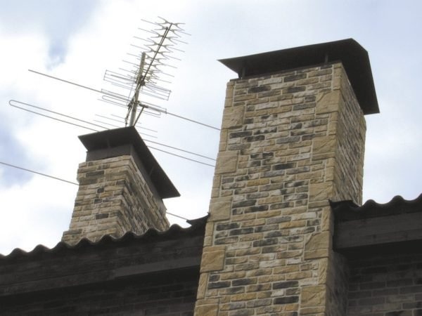 Каменная дымовая труба над крышей