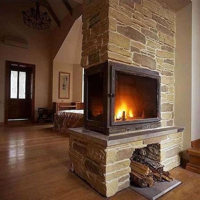 Камин с оригинальной отделкой из каменного шпона
