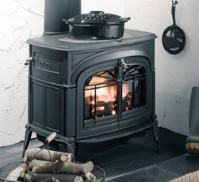 Чугунная печь, установленная на стене
