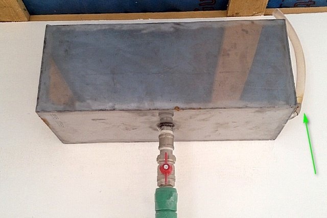 Сбоку емкости находится кусок прозрачного шланга, который служит 