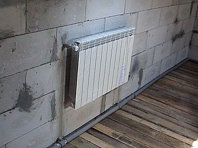 Нижняя магистральная труба будет закрыта финишным покрытием пола. Подводящие трубы уже встроены в стену
