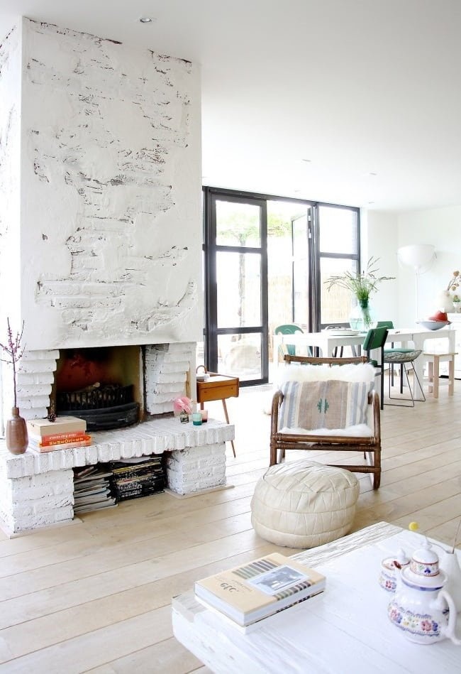 Классический дровяной камин прекрасно сочетается с белоснежным скандинавским интерьером