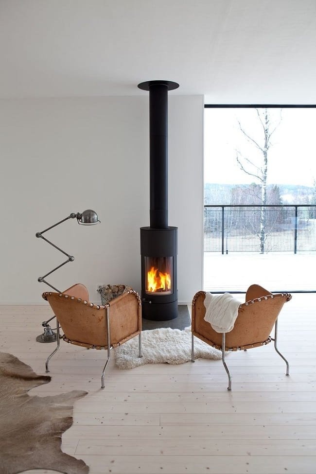 Необычный камин, выполненный из черного матового металла, идеально вписывается в скандинавский стиль интерьера.